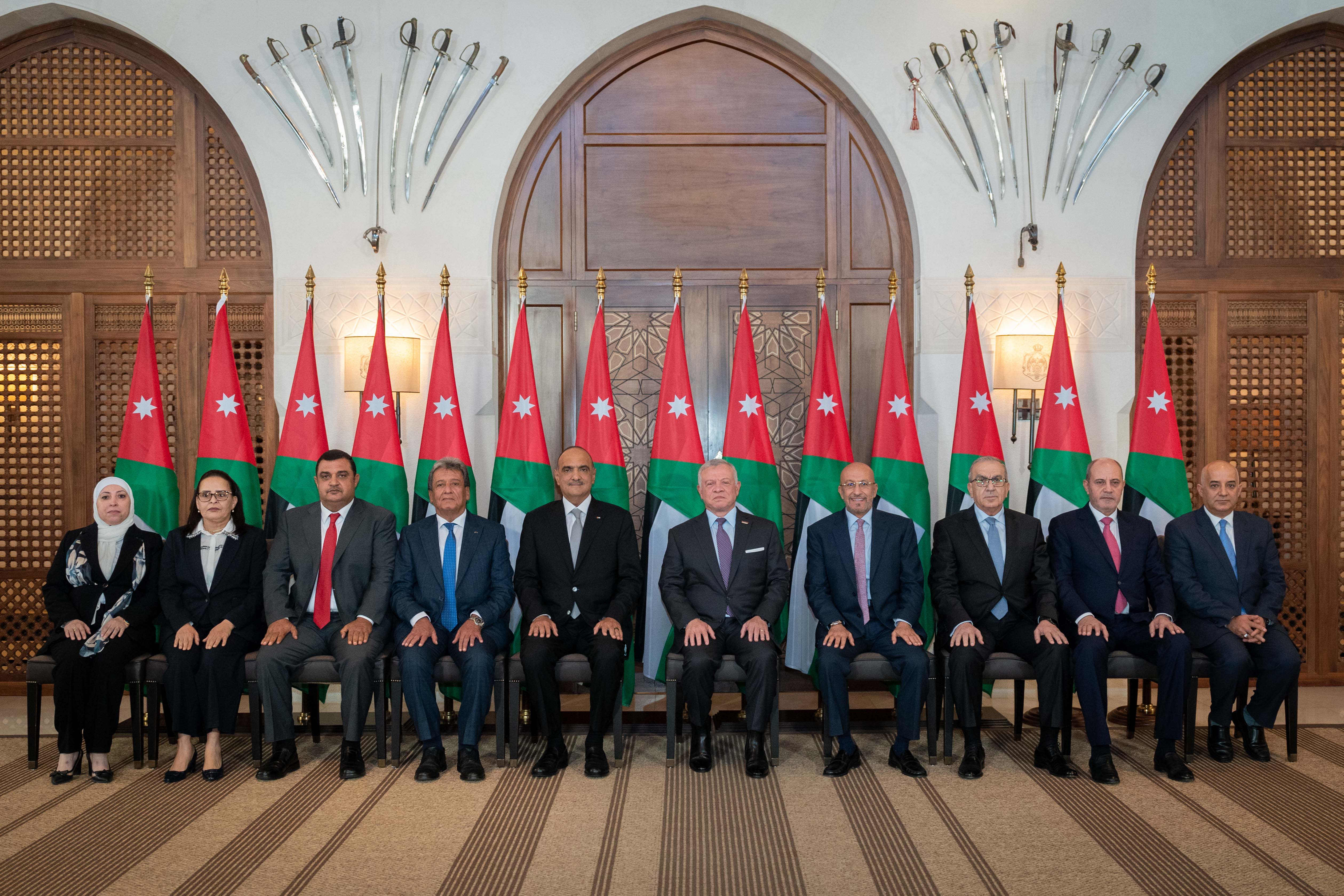His Majesty King Abdullah poses for a photo with new ministers during the swearing-in ceremony at Al Husseiniya Palace on Tuesday (Photo courtesy of Royal Court)